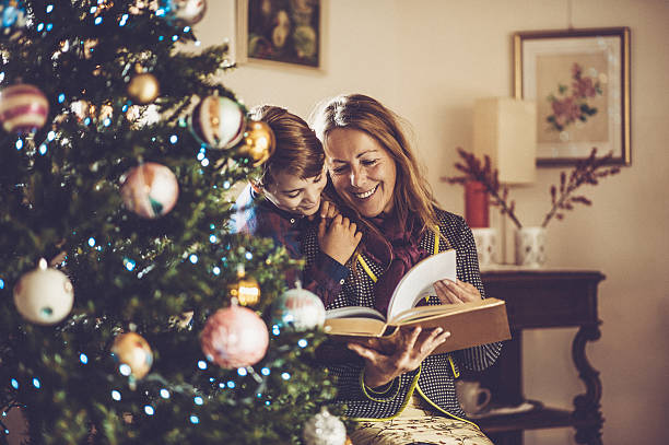Grandmother and Grandson reading Fairy Tales on Christmas Grandmother and Grandson reading Fairy Tales on Christmas christmas story telling stock pictures, royalty-free photos & images