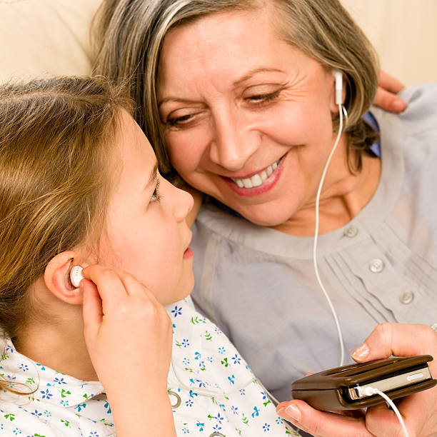 Granddaughter and grandmother listen to mp3 music headphones together...