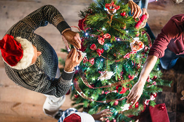 grandparent making the christmas tree - vrouw kerstboom versieren stockfoto's en -beelden