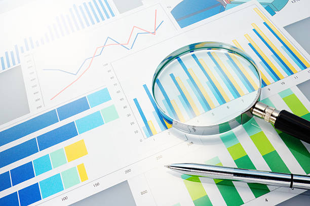 Graphs, magnifier and pen. Analyzing finances. report document stock pictures, royalty-free photos & images