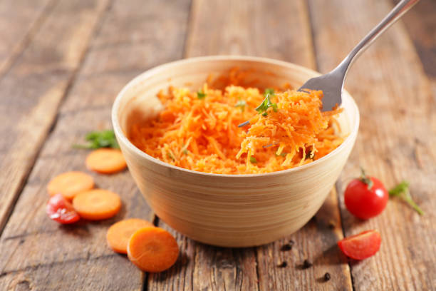 grated carrot- carrot salad and fork stock photo