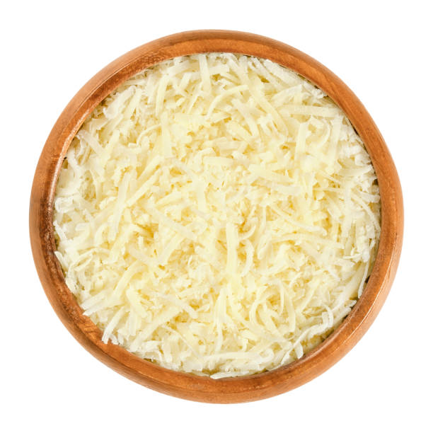 Grated Parmesan cheese in wooden bowl over white Grated Parmesan cheese in wooden bowl. Parmigiano-Reggiano. Italian hard, granular cheese, of slightly yellow color, made of unpasteurized cow milk. Macro food photo, closeup, from above, over white. parmesan cheese stock pictures, royalty-free photos & images