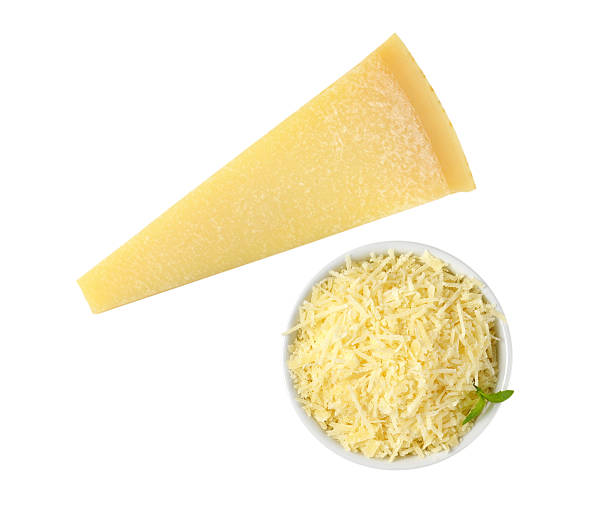 grated parmesan cheese bowl of grated parmesan and whole cheese wedge parmesan cheese stock pictures, royalty-free photos & images
