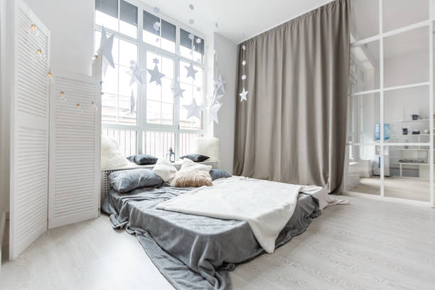 Dormitorio gris con ventana grande, cama de matrimonio en estilo escandinavo - foto de stock