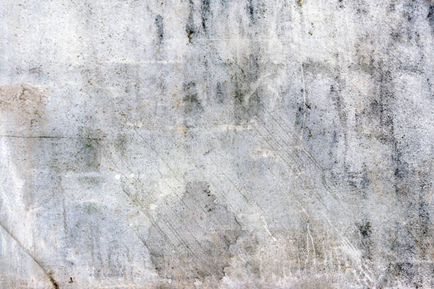 Gray wall with scuffs and scratches. Empty background with a texture of cracked old plaster. stock photo