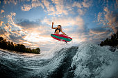 istock great view of woman jumping over big splashing wave on surf style wakeboard. 1278022309