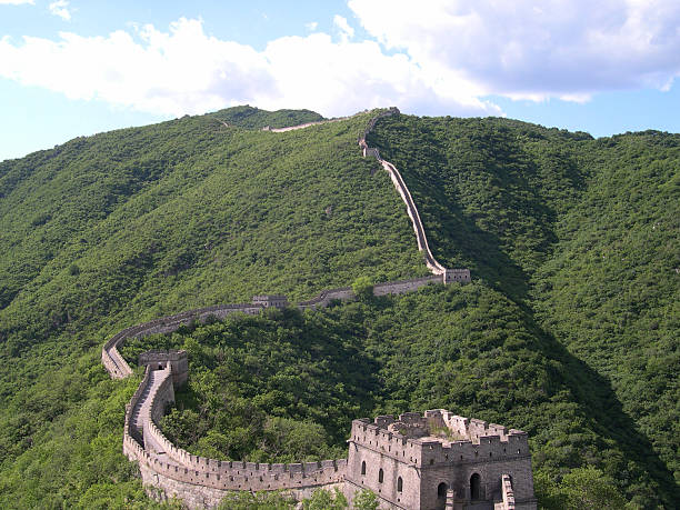 Great Wall of China with Sky Great Wall in the lush mountains at Mutianyu, China, from a distance in the summer on a clear, blue sky day mutianyu stock pictures, royalty-free photos & images