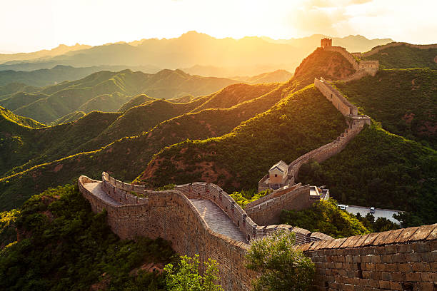 great wall unter der sonne bei sonnenuntergang - chinesische mauer stock-fotos und bilder