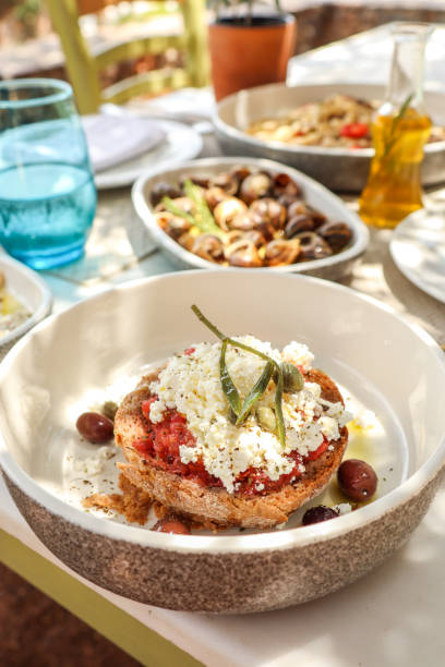 Greek Food Table with Cretan delicacy Dako Feta Olives and Tomato stock photo