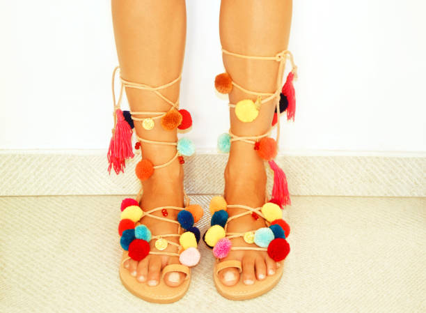 greek leather bohemian sandals with pom pom stock photo