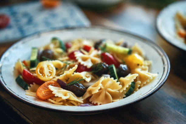 Greek Salad with Farfalle Pasta, Tomato, Cucumber, Bell Pepper, Olives and Feta Cheese stock photo