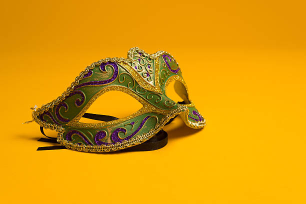 verde e ouro mardi gras e máscara veneziana sobre fundo amarelo - carnival mask imagens e fotografias de stock