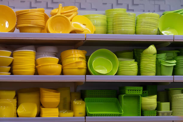 Green and yellow plastic saucers and plates on store shelves. stock photo