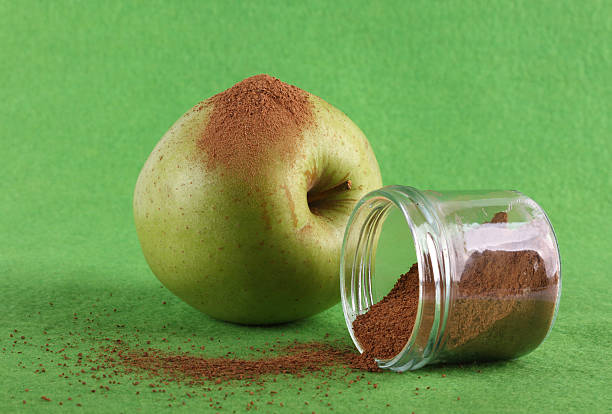 Green apple on green background with cinnamon stock photo