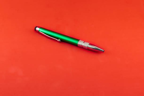 Green ballpoint pen on red background stock photo