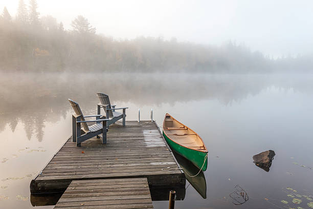 Green Canoe and Dock on a Misty Morning stock photo