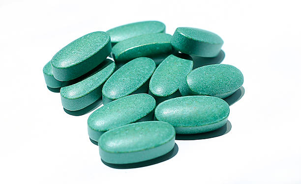 Green colour pills on a white background stock photo