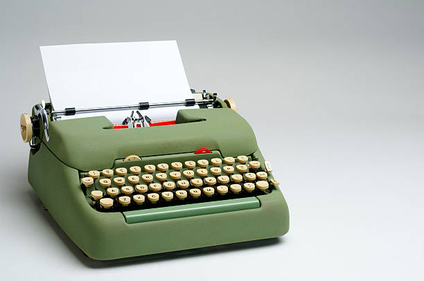 Green Electric Typewriter with Blank Paper A green electric typewriter with a blank sheet of paper. typewriter stock pictures, royalty-free photos & images