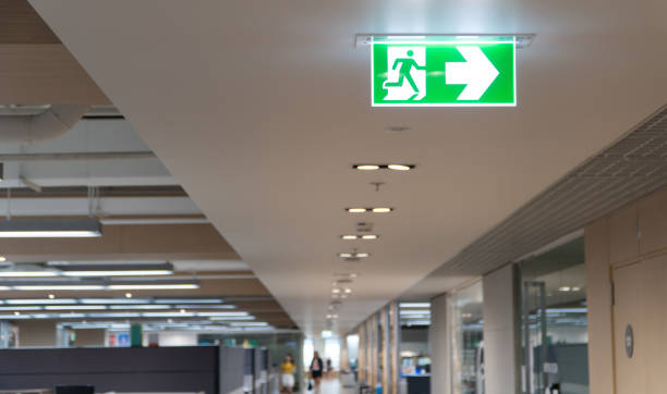 Green fire escape sign hang on the ceiling in the office. Green fire escape sign hang on the ceiling in the office. evacuation stock pictures, royalty-free photos & images