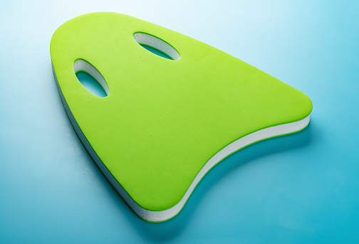 Green Floating Pad For Kids To Study Swimming On Blue Background Stock Photo - Download Image