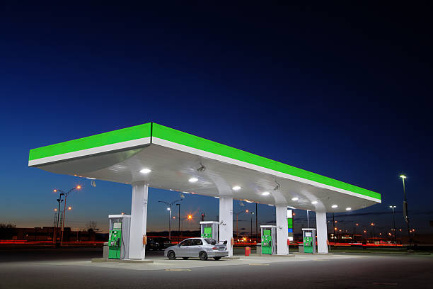 green gas station lights at night - reparationsverkstad bildbanksfoton och bilder