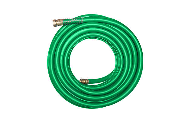 Green hose isolated on white A new green coiled rubber hose isolated on white. garden hose stock pictures, royalty-free photos & images