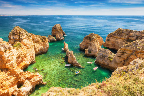 Green lagoon of Lagos Boats in the bay of rocky arches algarve photos stock pictures, royalty-free photos & images