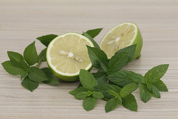 Green lime with fresh mint and basil / Two halves of lime on kitchen...