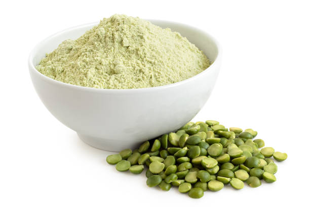 Green pea flour and green split peas. Dried green pea flour in a white ceramic bowl next to a pile of green split peas isolated on white. pea protein powder stock pictures, royalty-free photos & images