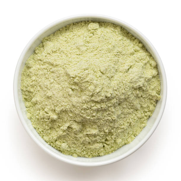 Green pea flour. Dried green pea flour in a white ceramic bowl isolated on white. Top view. pea protein powder stock pictures, royalty-free photos & images