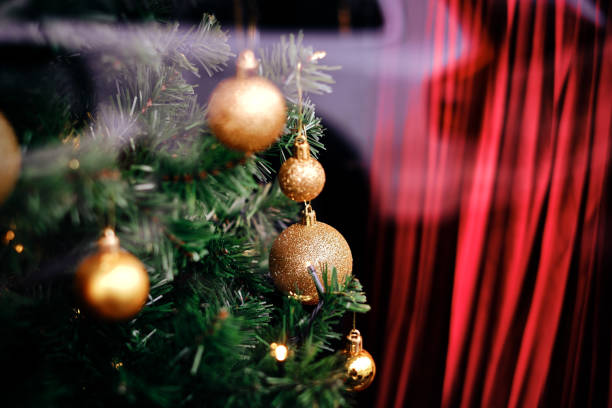 Green pine branches with golden christmas ornaments stock photo