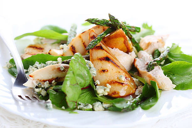 Green salad mix with pears and grilled asparagus with fork stock photo