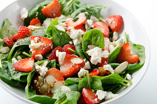 SEVERAL MORE IN THIS SERIES. Fresh salad of baby spinach leaves, sliced strawberries, slivered almonds, feta cheese, and a light dressing. Shallow DOF.