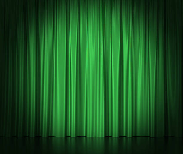 Green silk curtains for theater and cinema spotlit light in stock photo
