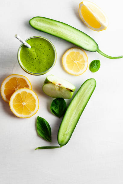 Green Smoothie with Antioxidants, Fresh Fruit Juice Drink in Glass, Cucumber, Orange - Fruit, Smoothie, Juice Bar, Antioxidant orange smoothie stock pictures, royalty-free photos & images