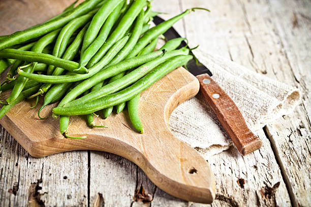 green string beans and knife green string beans and knife closeup on wooden board green bean stock pictures, royalty-free photos & images