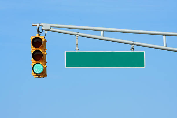 Green traffic signal light with sign stock photo