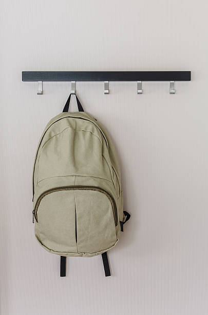 green travel backpack hanging on the wall stock photo