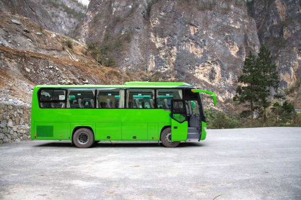 Green travel bus for transport of tourism stop at parking, passenger bus in Shangri-la, China for travel in Balagazon national park. stock photo