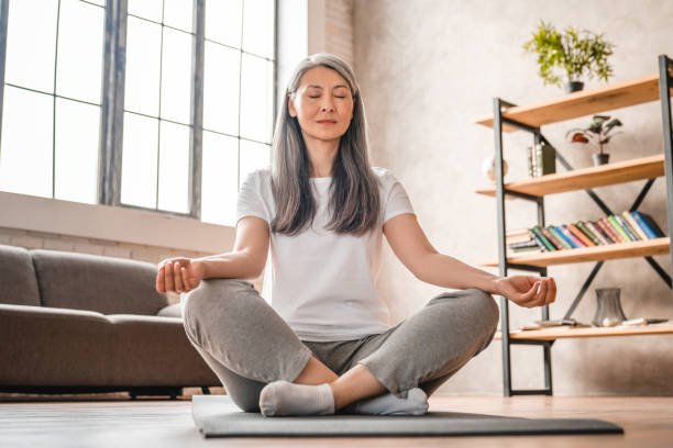 Grey-haired mature caucasian woman meditating at home Grey-haired mature caucasian woman meditating at home zen like stock pictures, royalty-free photos & images