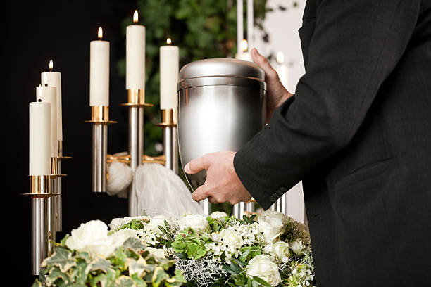 Grief - urn Funeral and cemetery Religion, death and dolor  - mortician on funeral with urn ash stock pictures, royalty-free photos & images