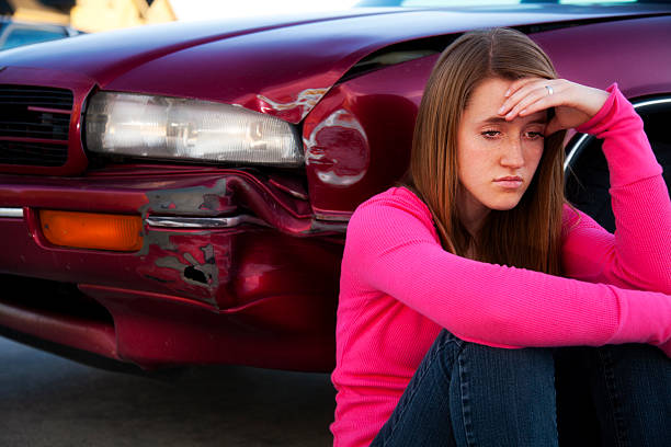 grieving female teenager contemplates fender bender - fixing car pain stockfoto's en -beelden
