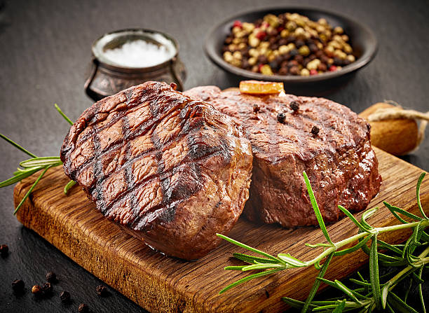 grilled beef steaks grilled beef steaks with spices on wooden cutting board barbecue meal stock pictures, royalty-free photos & images