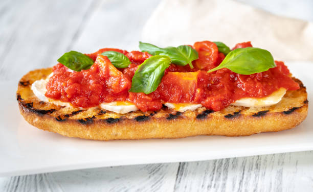 Grilled bread with mozzarella and tomatoes stock photo