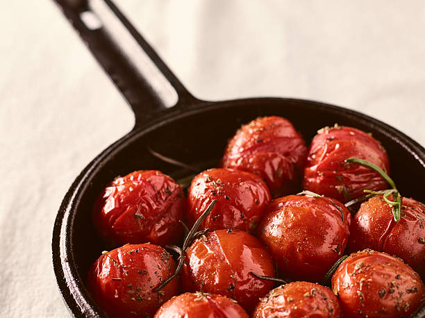 Grilled cherry tomatoes and cast iron pot stock photo
