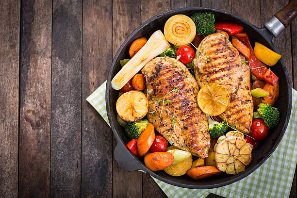 grilled chicken breast and vegetables in the pan - barbecue maaltijd stockfoto's en -beelden
