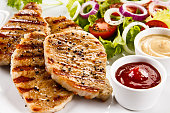 Grilled chicken breast and vegetables salad on white background
