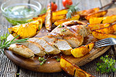 Grilled chicken breast with lemon dipping sauce and rosemary potato wedges