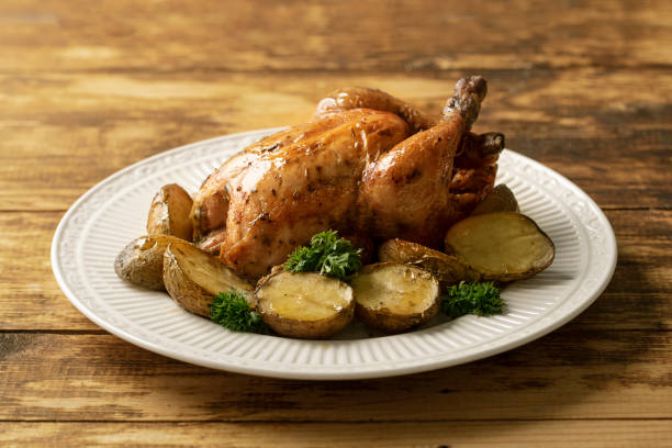 Grilled Chicken with potatoes on a wooden table stock photo