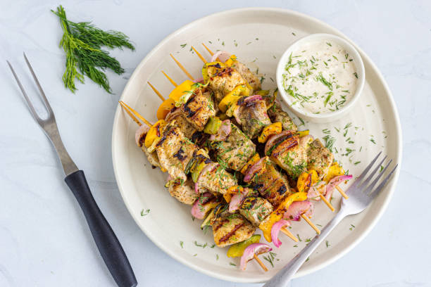 Grilled Fish Kebab in a Plate with Condiment Garnished with Fresh Dill stock photo